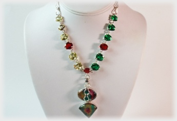 The Glowing Necklace of Faceted Gemstones and Dichroic Glass framed in hand sculpted silverworks.
